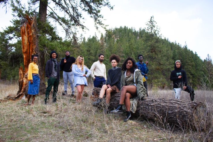 Black Student Union Members stand posed around a fallen log