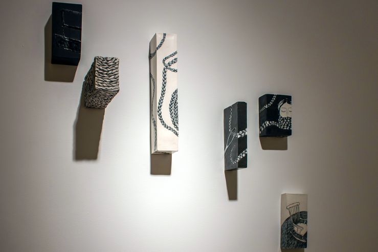 Dramatic shot of some rectangular, 3D mixed media pieces of art protruding from the wall
