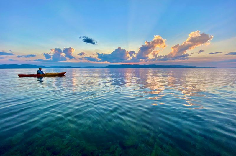 Colorful sunset on flathead lake with a canoe on the water. 