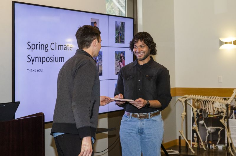 Man presenting award at symposium