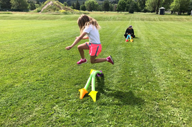 Child jumping over a short fence