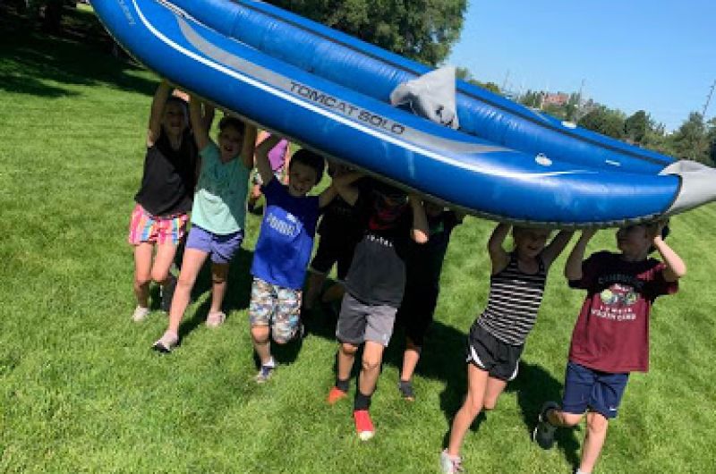 Children carrying an inflatable raft