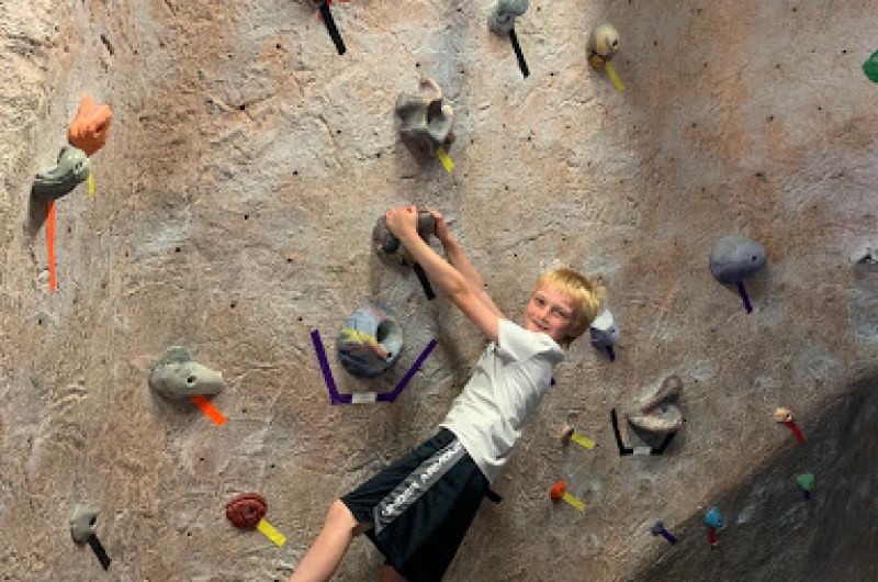 Child climbing on a rock wall in a climbing gym