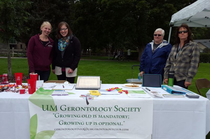 UMGS table at Welcome Feast with banner