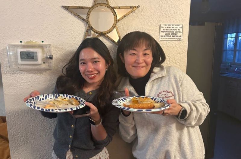 Two women smiling holding plates of food