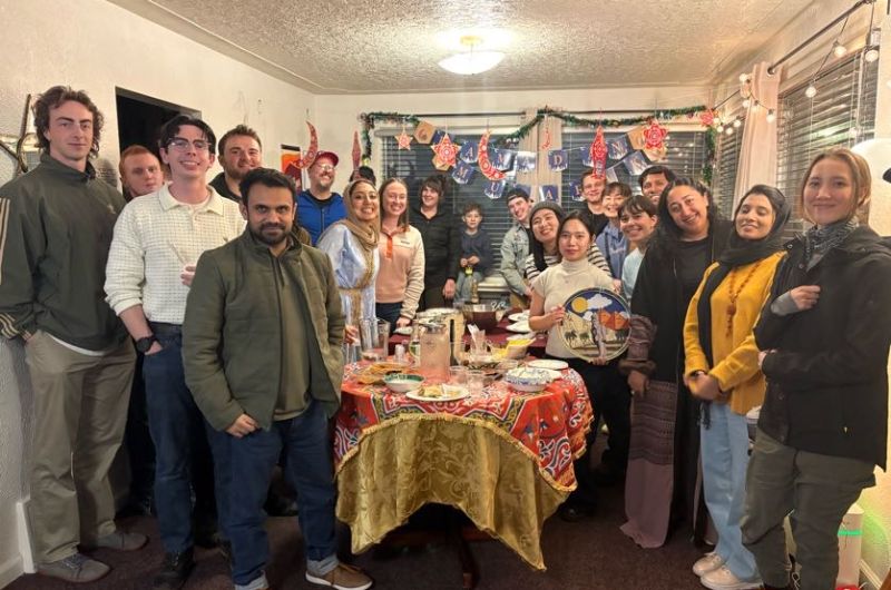 Group of students posing for a photo in a dining room