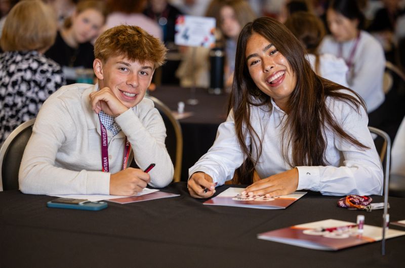 Two students smiling at the camera.