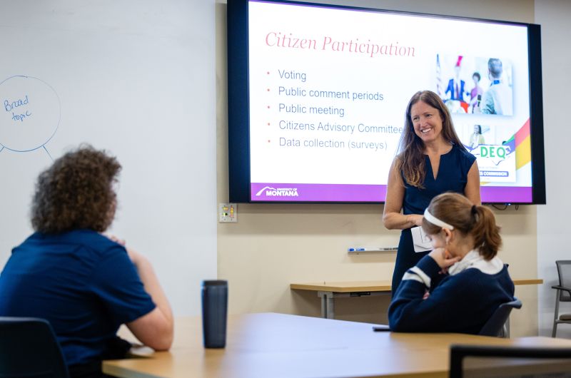 A teacher presenting  Citizen Participation with a powerpoint