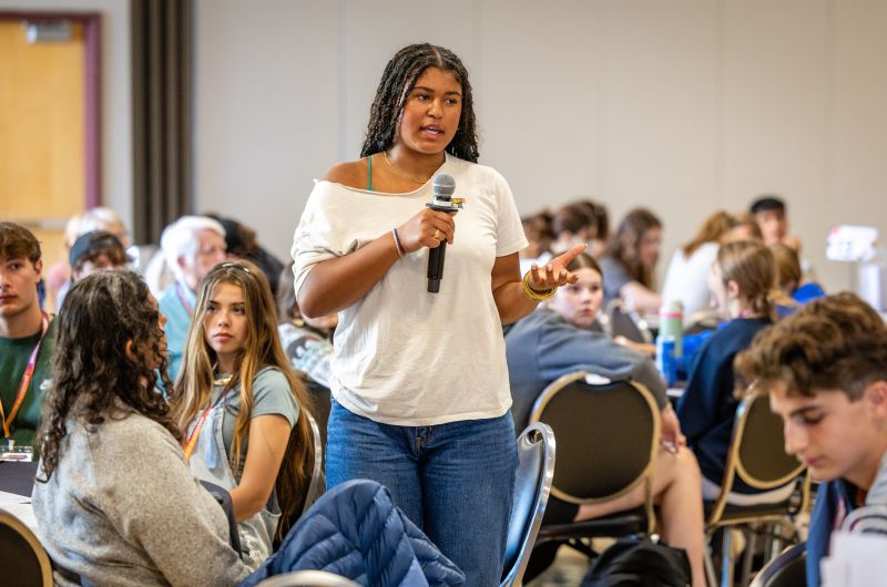 A student speaking to a room full of students