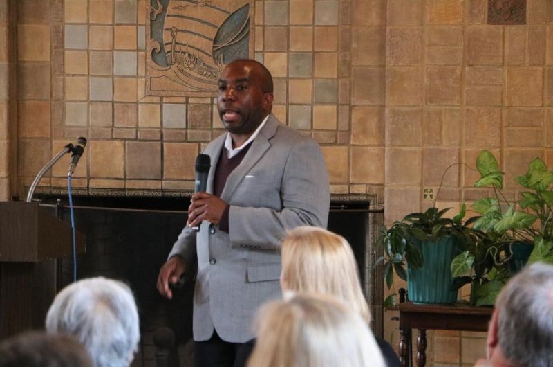 Dr. Goins speaks into a microphone