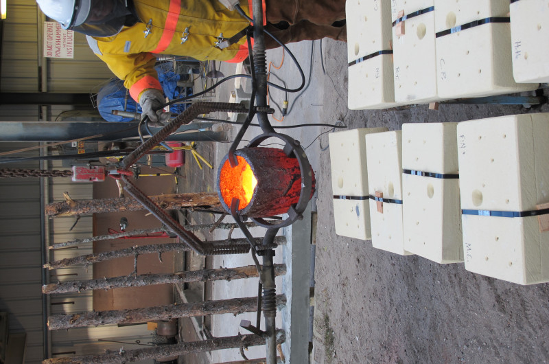 Patrick Eckman gets the crucible in place above a mold.