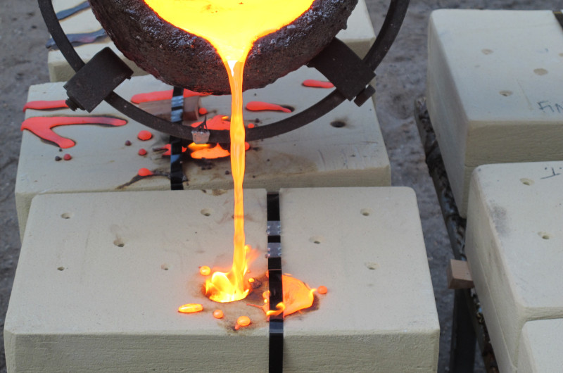 Allen and Evanger pour the molten bronze into a mold.