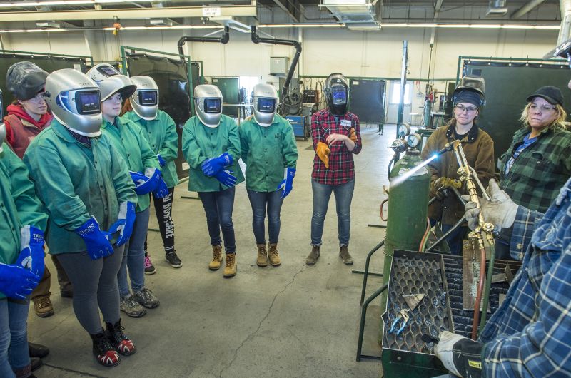 Girls from the GRIT program watch a welding demonstration.