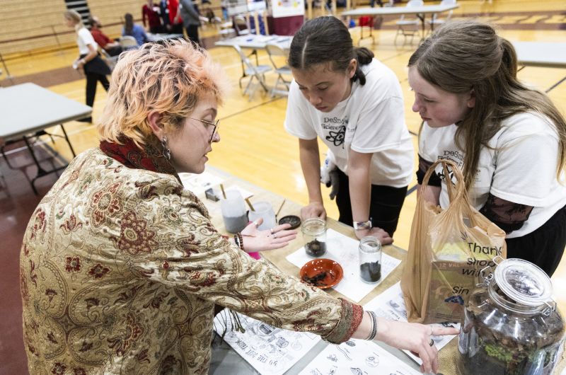 person showing students a sample of soil