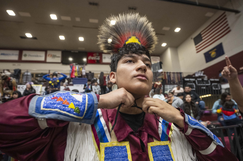 Former student tying regalia to head