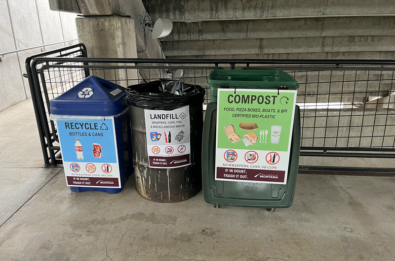 recyling, landfill, and compost bins lined up in a concourse