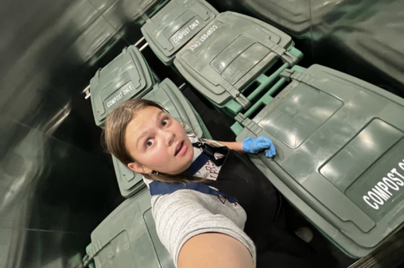 zoe takes a selfie with 6 compost bins in the elevator