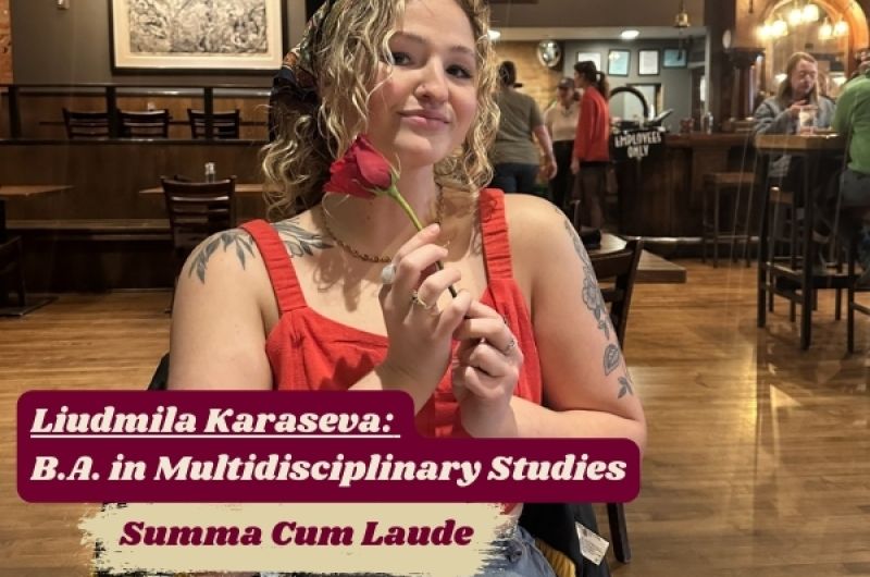 Liudmila smiles, holding a single rose