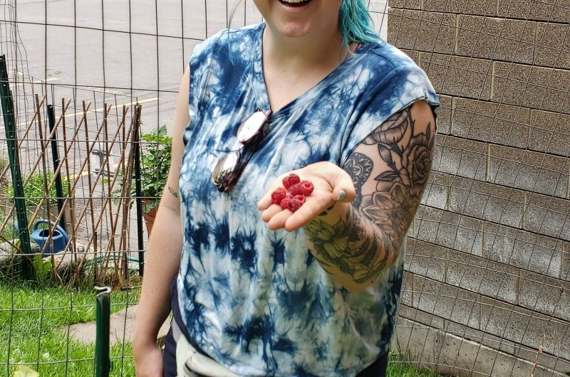 Student gardener shows off some fresh picked raspberries