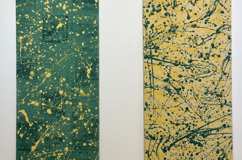 two side by side vertical abstract paintings, left is green backdrop with darker green staining and yellow drops, right is yellow backdrop and green paint