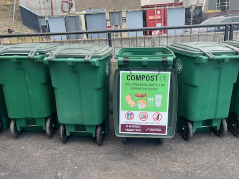 line of large green compost bins