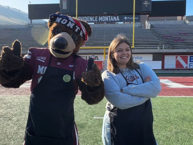 our intern zoe poses with Monte on the football field