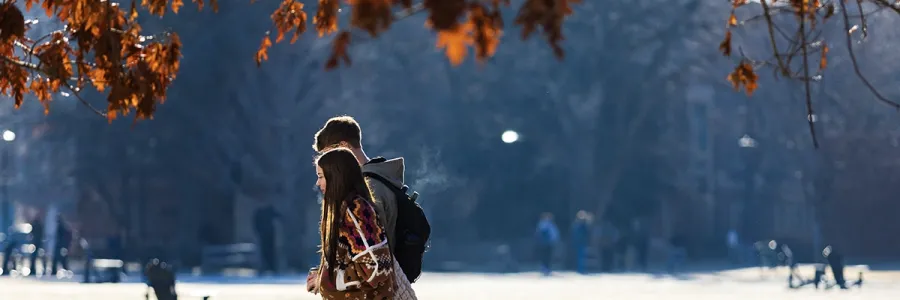Students walk in a pair on a cold morning on campus 