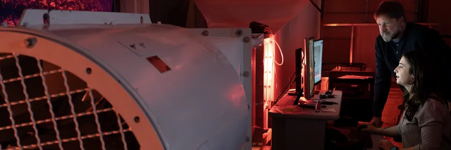 A student and professor focus in a research lab