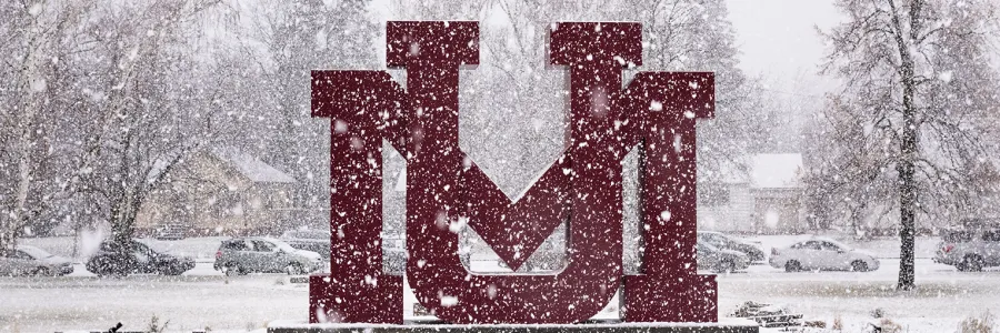 The UM Sign, known as the "Grizzly Gate" sits during snowfall.