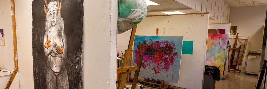view of a row of art studios with paintings in progress in each