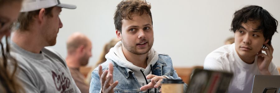 group of three students with two listening to one talk