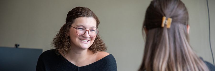 two people sitting facing each other and talking
