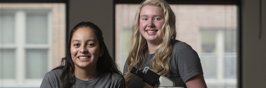two students posing and smiling for the camera