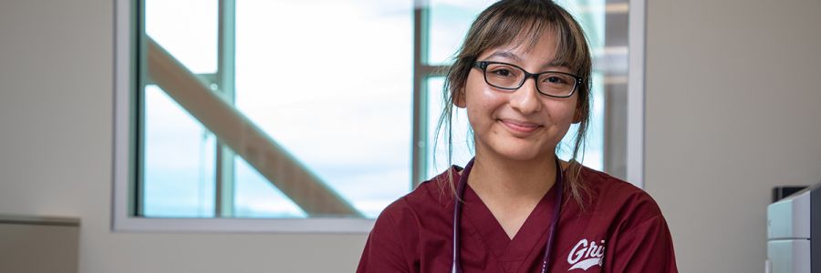 headshot of smiling student in Griz logo scrubs