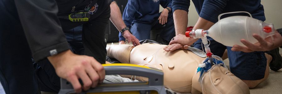 group of people practicing CPR on a training dummy