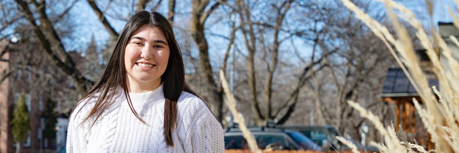 headshot of woman smiling outside in sharp fall sunlight