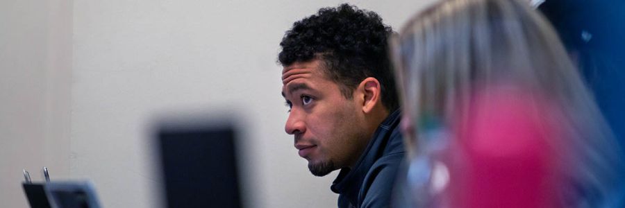 row of students with last one in focus and looking up at professor