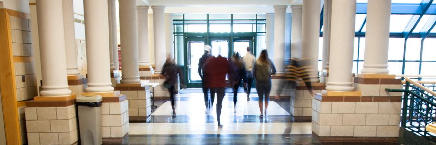 students walking in the main hallway of the Gallagher Business Building