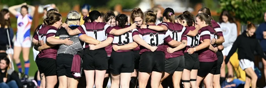 Members of UM Club Women's Rugby team huddle before a game begins