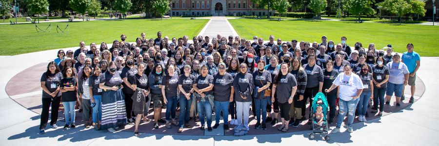 large group of CoLang attendees in a group on the UM Oval on a sunny day