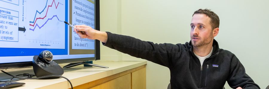 professor pointing at graphs on a computer screen