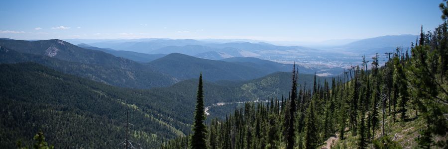 range of mountains viewed from the top of one with a town below in the distance