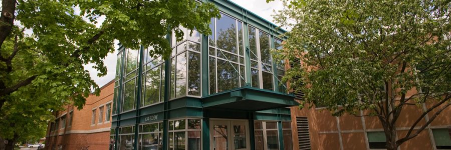 the front enterance of the Curry Health Center on a sunny day surrounded by tree