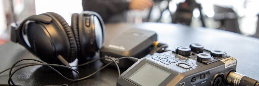 large studio headphones plugged into other audio equipment on a table