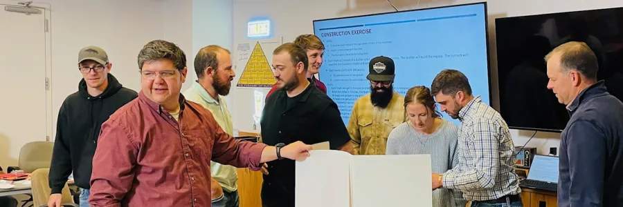 Employer leaders in business casual attire having a discussion in a conference room.