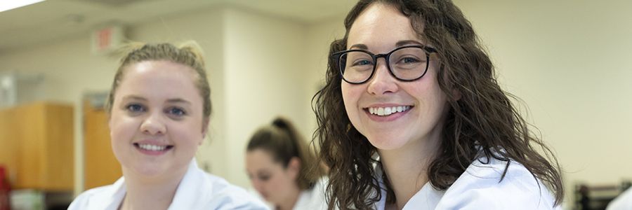 two smiling health students looking into the camera
