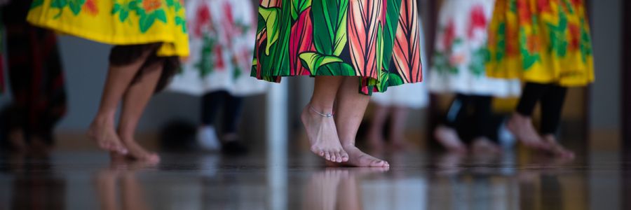 view of people's feet dancing in brightly colored skirts