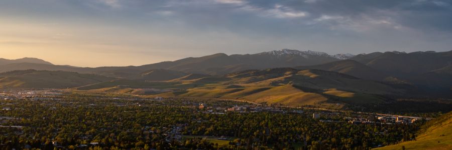 Missoula from hill south of town with snowy mountains in the distance