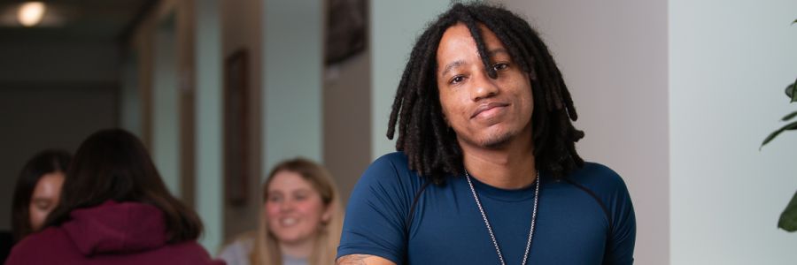 smiling student sitting at a table in the Missoula College library