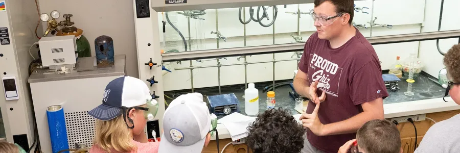 A UM student leads a lab activity with elementary school students